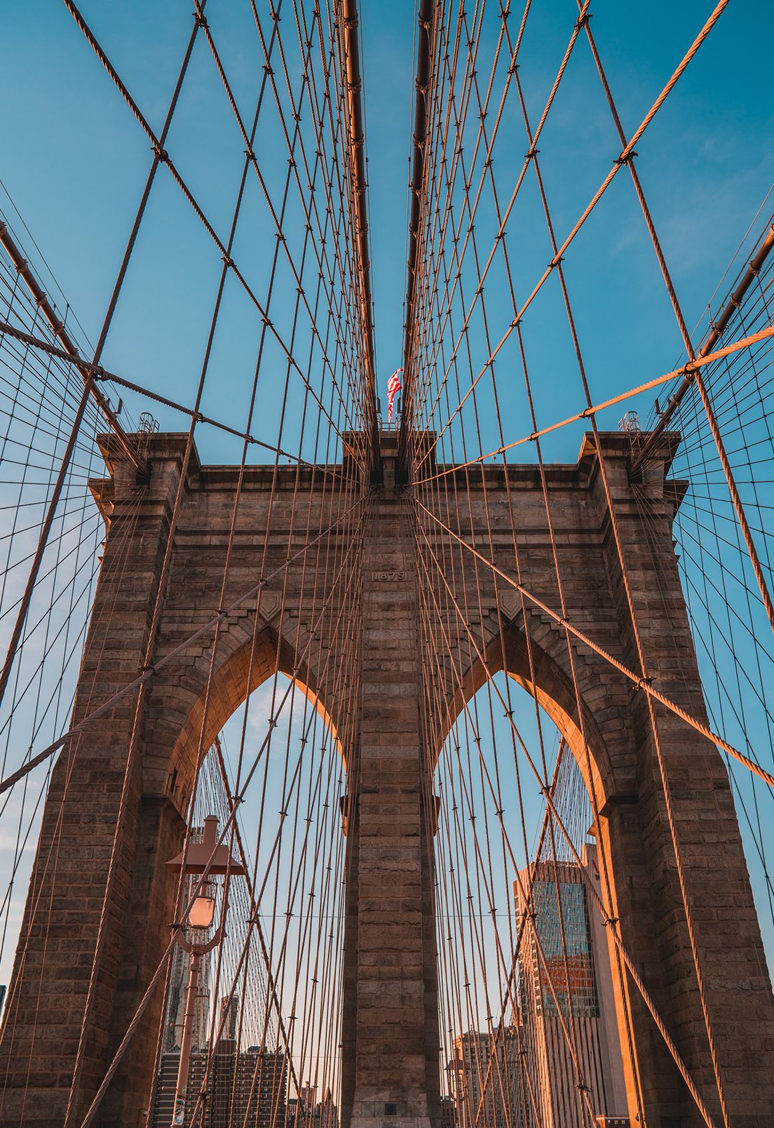 Representing New York is the Brooklyn Bridge in the daytime.