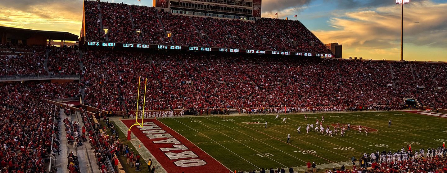 Gaylord Family Oklahoma Memorial Stadium at sunset full of fans during a game in Oklahoma.