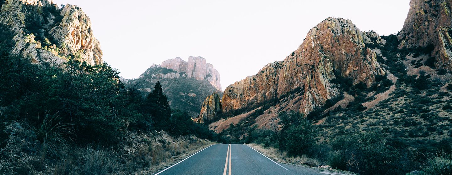 Highway surrounded by rock formations and hills in Texas.